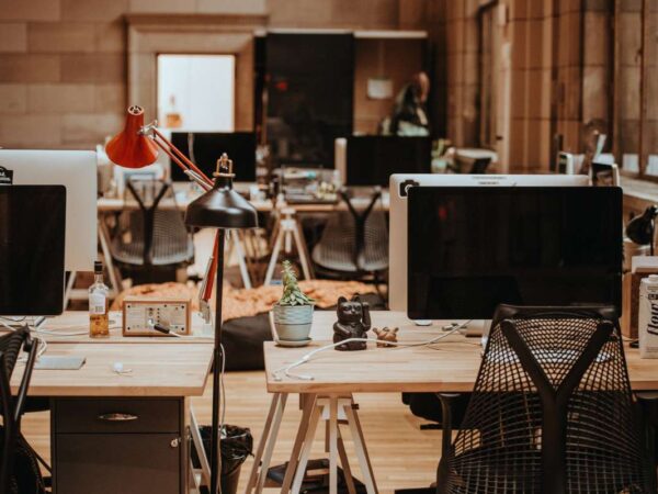 We see the inside of an obviously used flex space adorned by desks, computers, and other equipment.