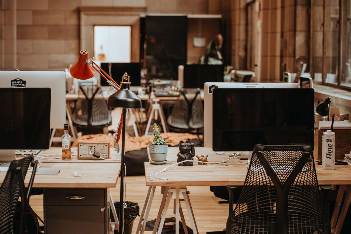 We see the inside of an obviously used flex space adorned by desks, computers, and other equipment.